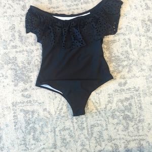 One piece woman's black bathing suit with ruffles